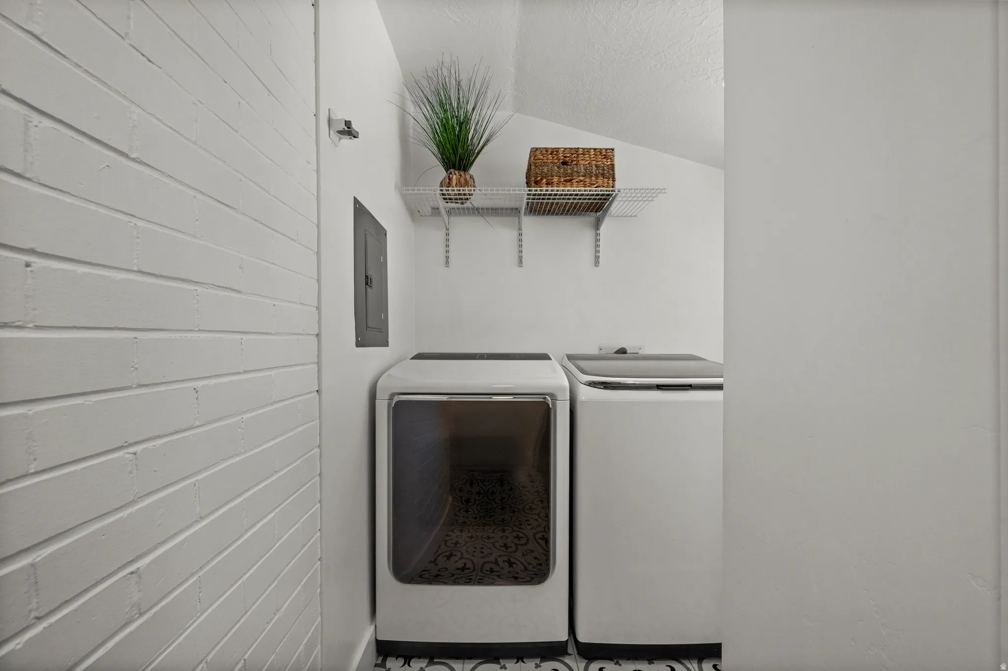 White-painted brick wall, patterned floor tile, and wall-mounted shelving
