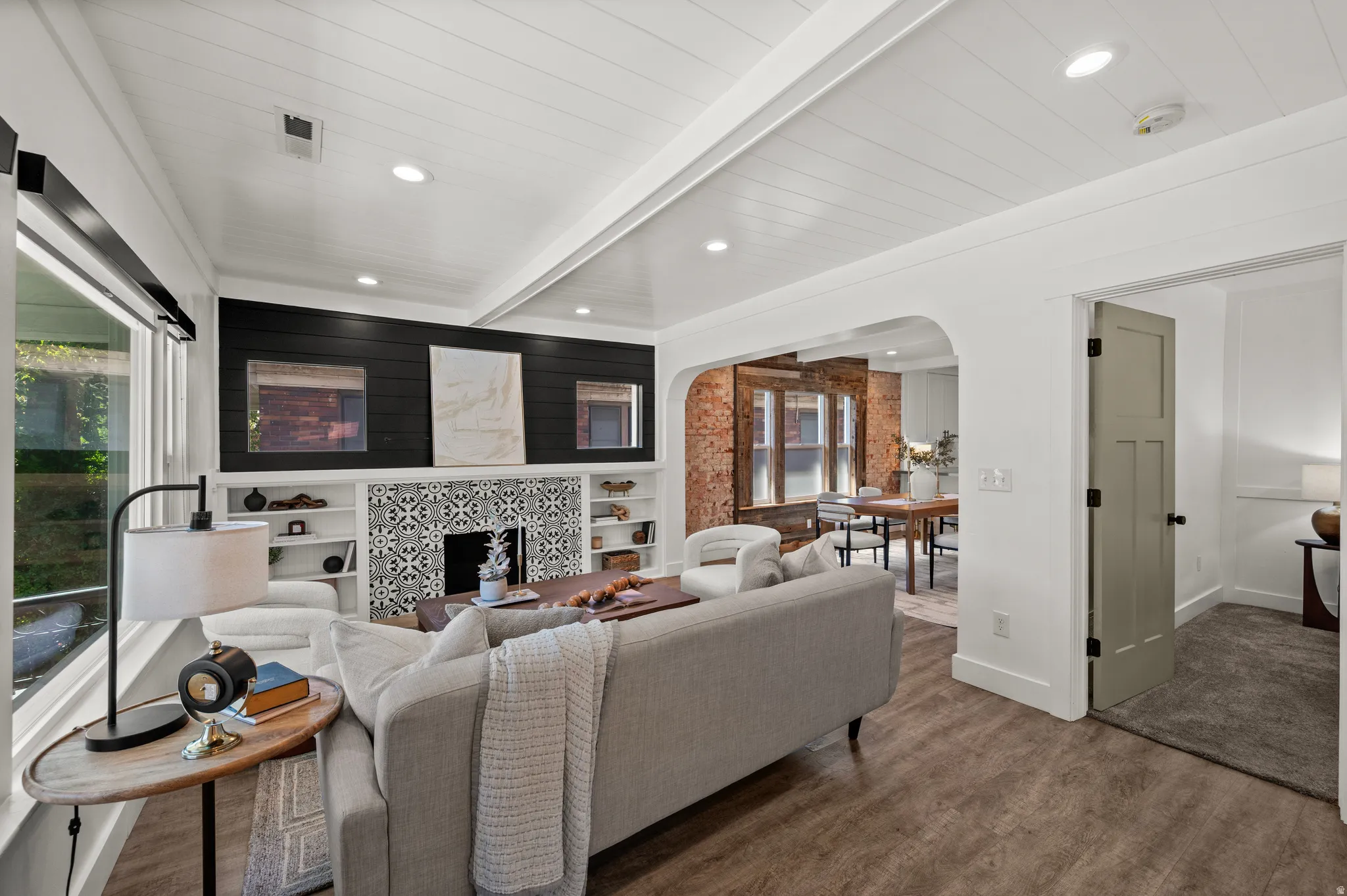 Wood-finish flooring, white shiplap ceiling, and arched room entry