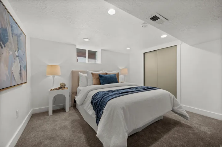 Plush carpeting, recessed lighting, and a window for natural light