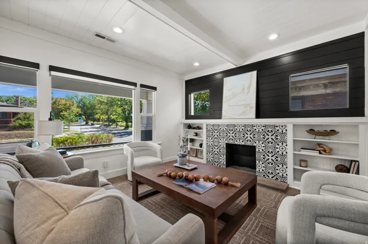 Living area featuring a fireplace with patterned tile surround, built-in shelving, white shiplap ceiling, recessed lighting, and large windows