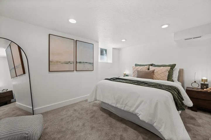 Recessed lighting, light gray carpet, white walls, and a window