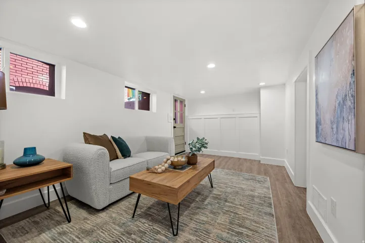 Recessed lighting, wood-finish flooring, white board and batten wall detailing, and a solid panel door