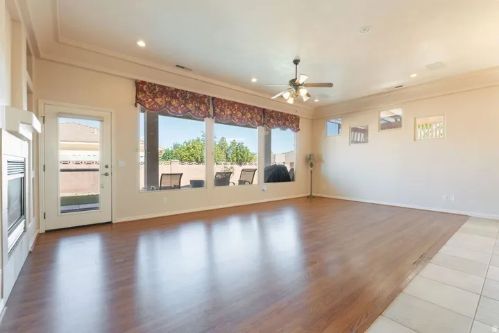 Recessed lighting, wood-finish flooring, fireplace, ceiling fan, and large windows