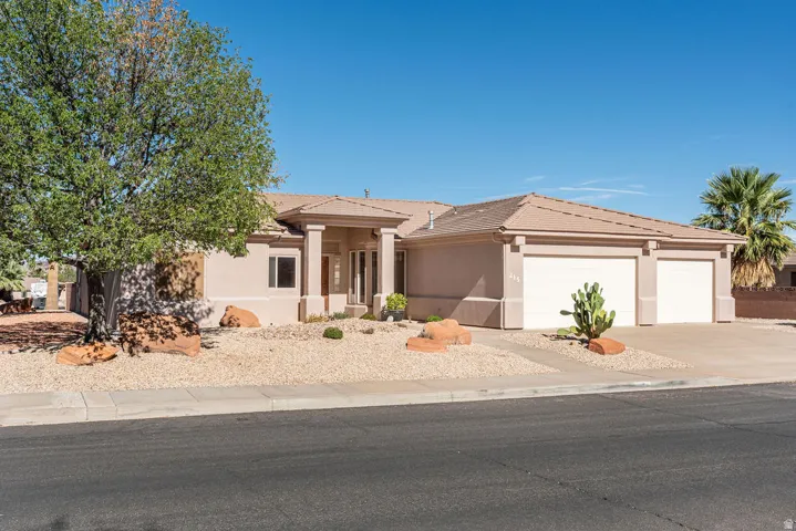 Stucco exterior with a tiled roof, columnar entry, and an attached two-car garage