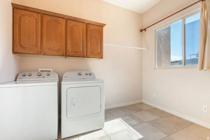 Recessed upper cabinetry, tile flooring, and a large window