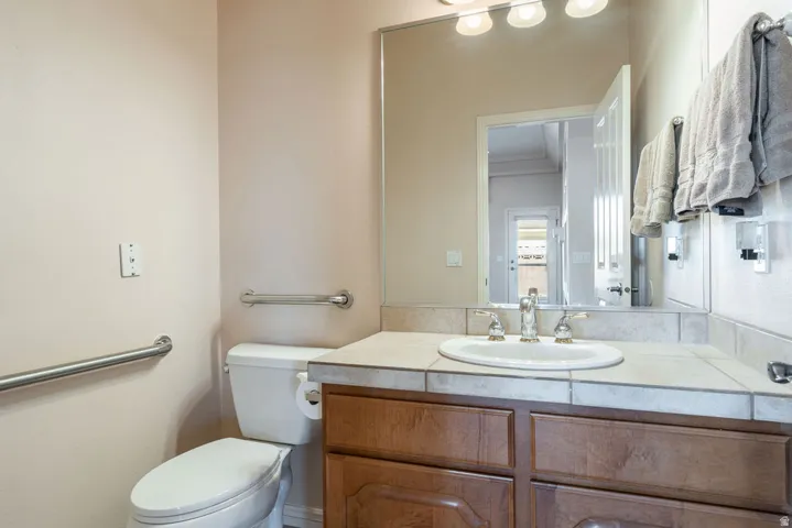 Bathroom vanity with a tile countertop, integrated basin sink, and a chrome faucet