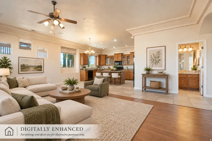 Open-concept living space featuring wood-finish flooring, a ceiling fan with integrated lighting, and crown molding