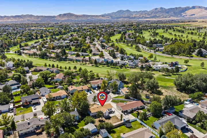 Expansive residential area with mature trees, green spaces, and distant mountains