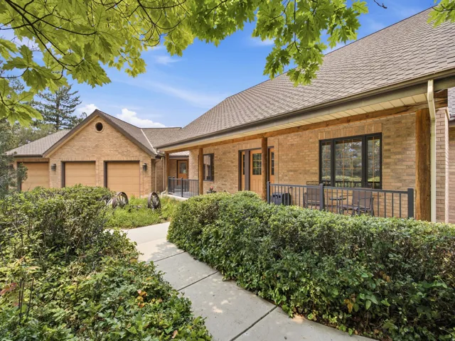 Brick exterior with a covered porch, two-car garage, and established landscaping
