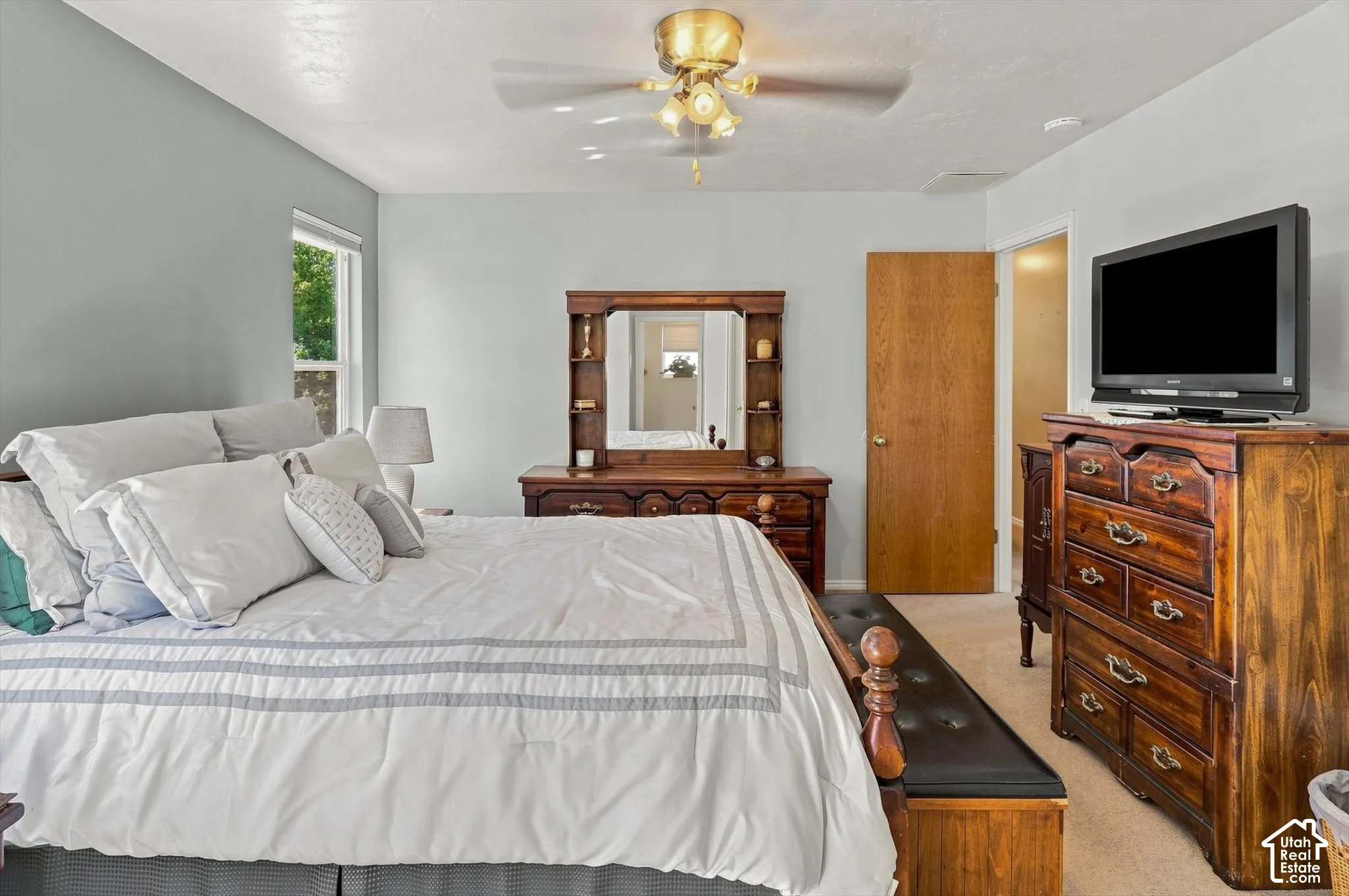 Recessed lighting, ceiling fan, neutral wall paint, wood-finish door, and carpeted flooring