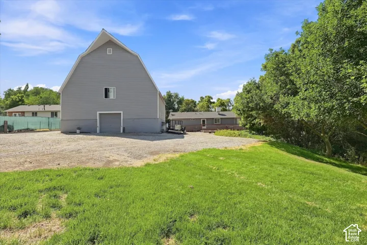 Gabled gray barn structure with a window and a garage door