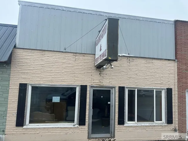 Light-colored brick facade with a metal panel upper story