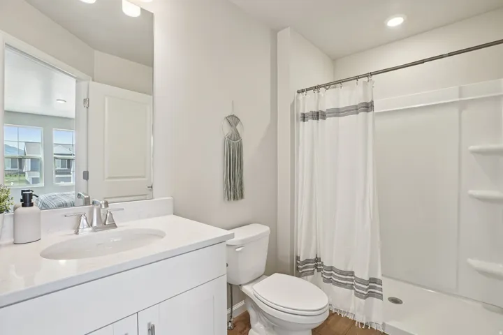 White vanity with a single basin sink and brushed nickel faucet