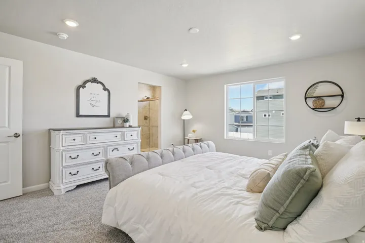 Recessed lighting and a light gray carpeted floor establish a neutral palette