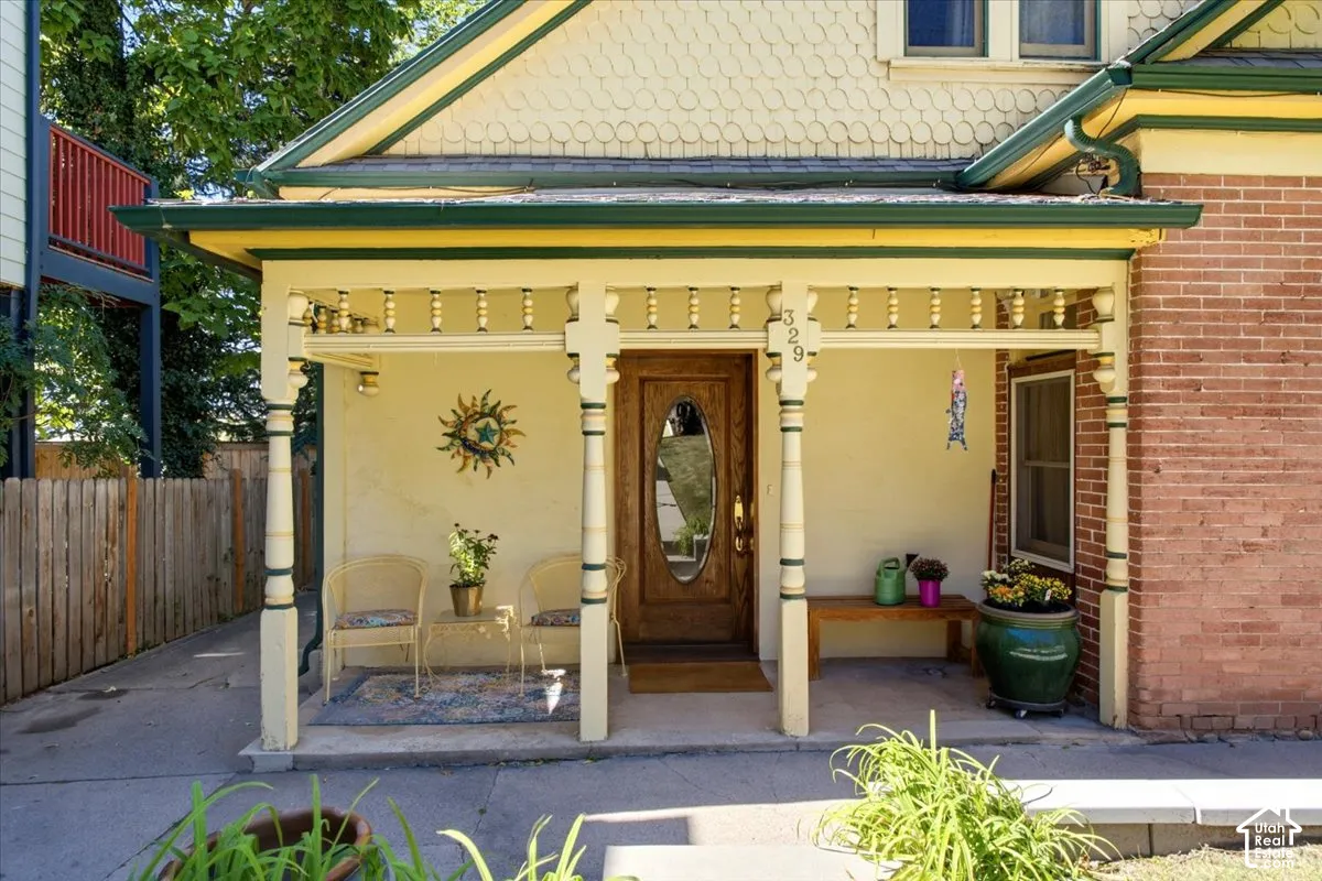 Covered front porch with decorative spindle railing known as 'gingerbread'.