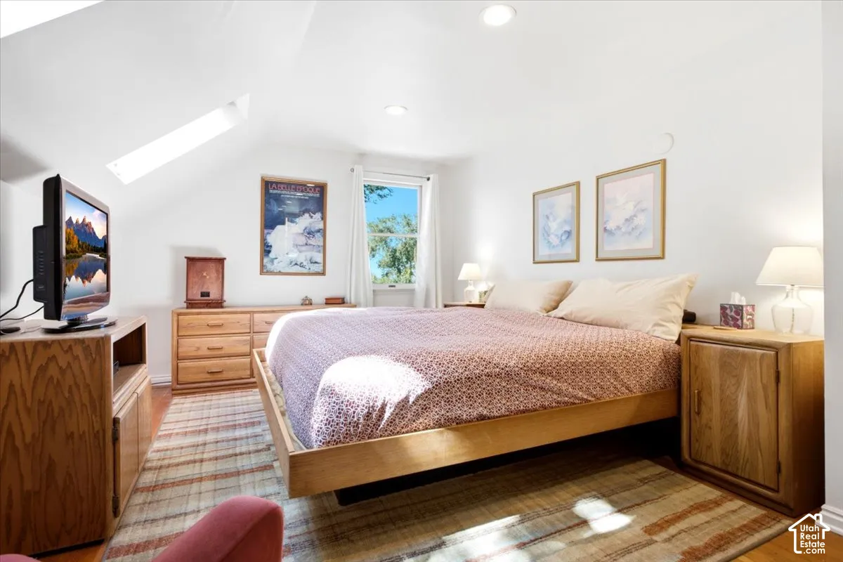 Sloped ceiling with recessed lighting and a skylight for ambient light at night.
