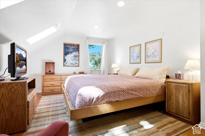 Sloped ceiling with recessed lighting and a skylight for ambient light at night.