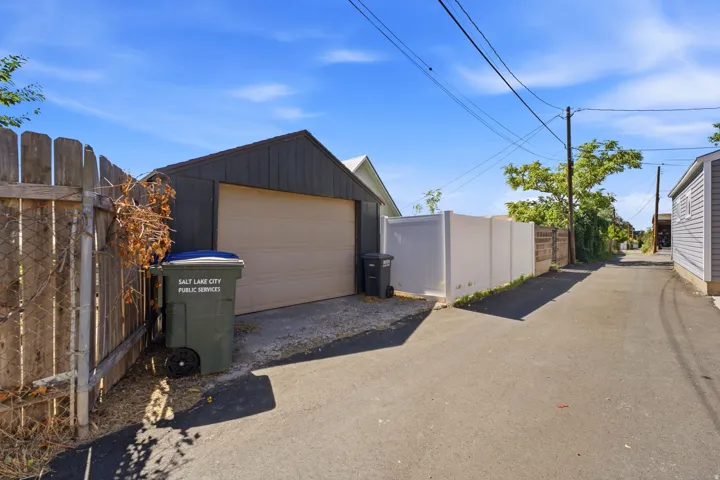Detached garage with a light-colored garage door and dark siding
