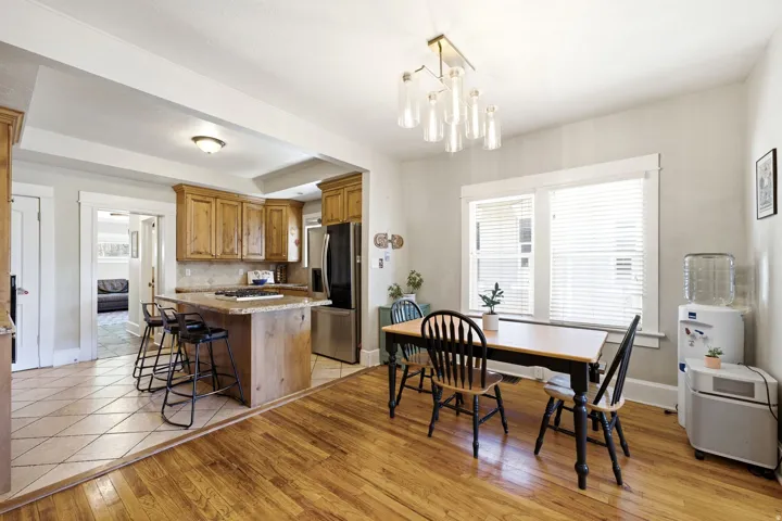 Kitchen with wood-finish cabinetry, stainless steel appliances, and a granite-style island