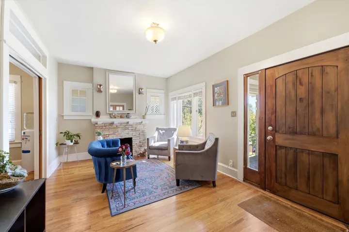 Hardwood flooring throughout, stone-clad fireplace, solid wood double entry doors with integrated sidelight, and crown molding