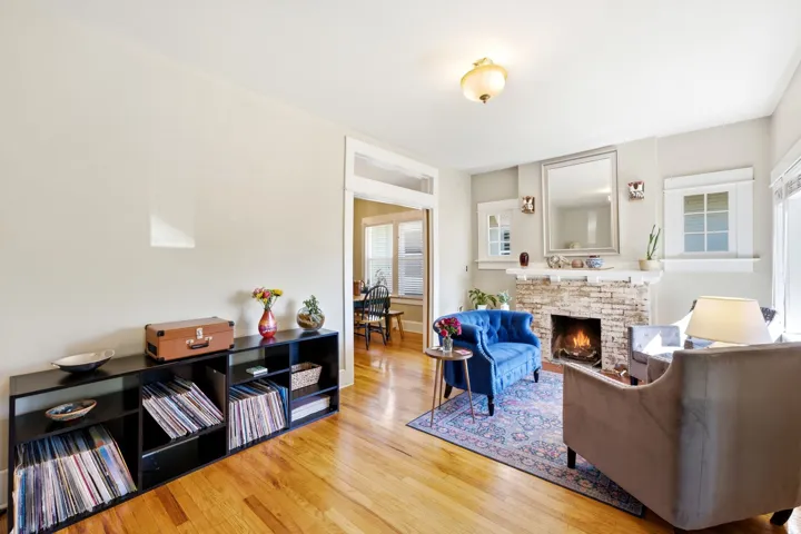 Hardwood flooring throughout, a brick fireplace with a mantel, crown molding, and a built-in light fixture