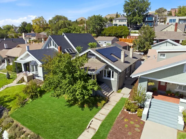 Gable roof home featuring solar panels, a front porch, and a bay window