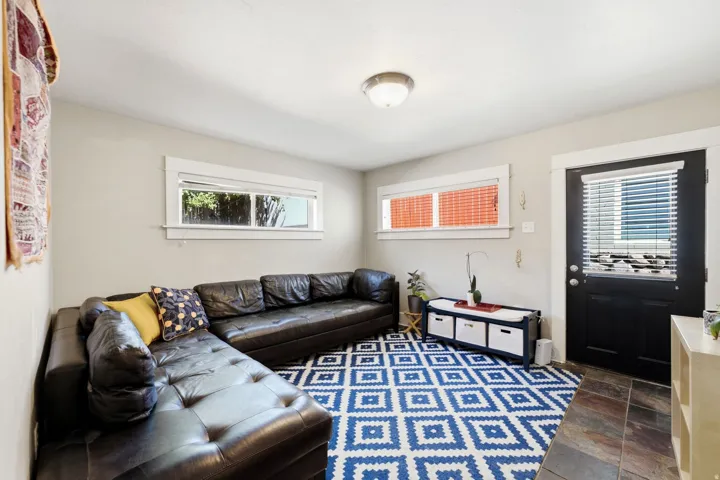 Recessed windows with crisp white trim, black door with integrated blind, flush mount ceiling light, and warm-toned floor tiles