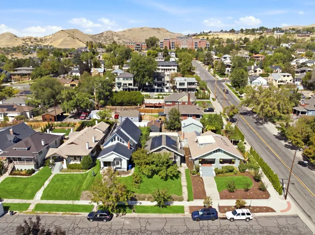 Residential neighborhood with mature trees, established landscaping, and mountain backdrop