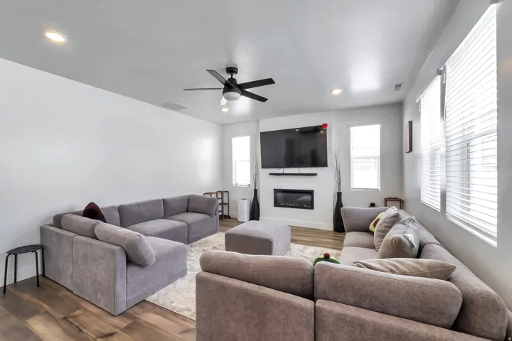 Open-concept living area featuring wood-finish flooring, recessed lighting, and a modern ceiling fan