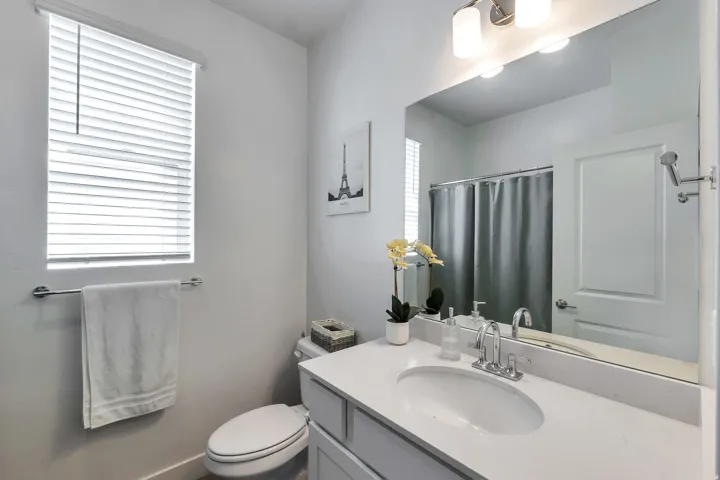 Bathroom featuring a vanity with an integrated sink, polished chrome faucet, and expansive mirror