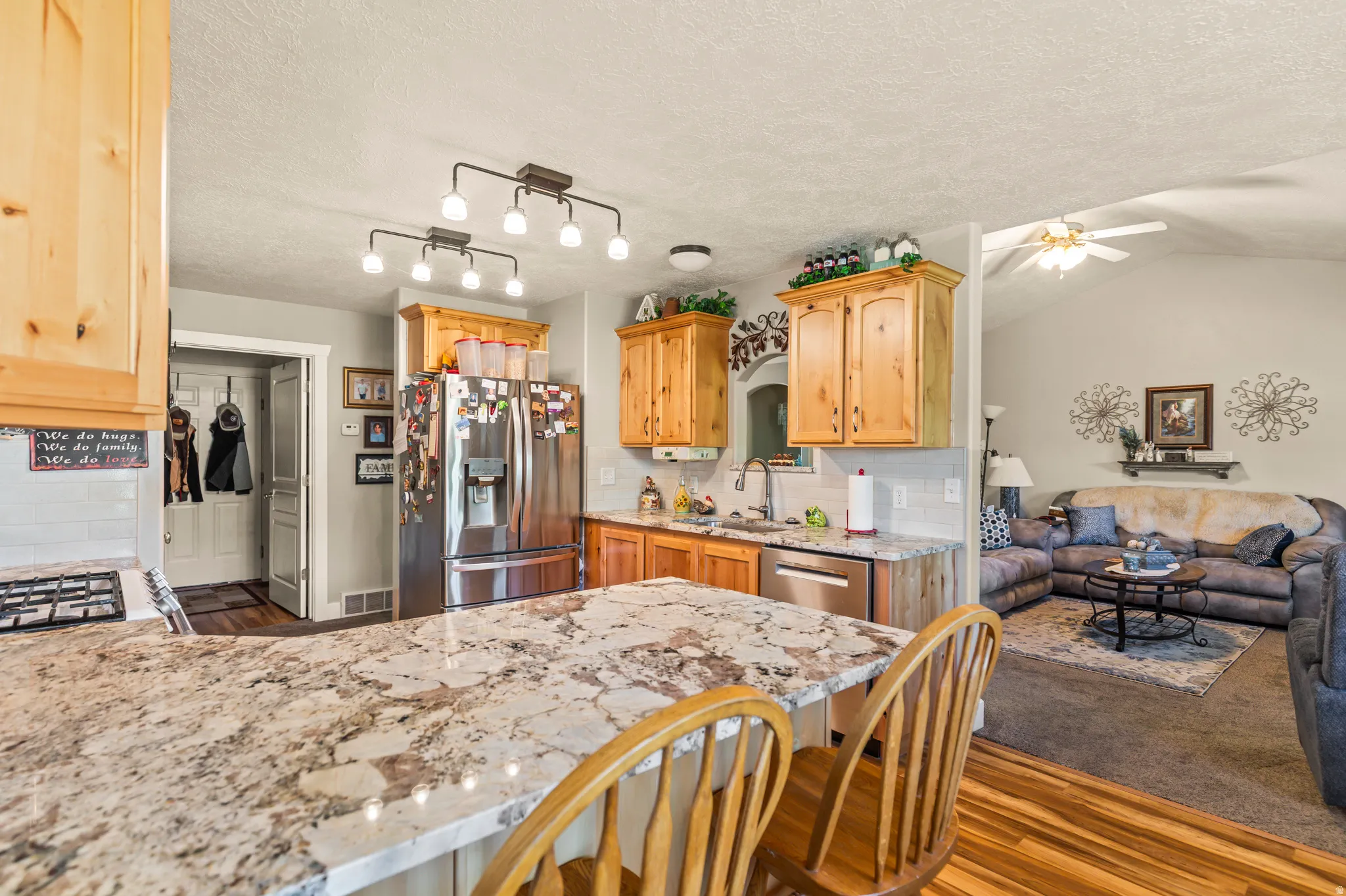 Kitchen featuring wood cabinetry, stainless steel appliances, and a breakfast bar with stone-look countertop