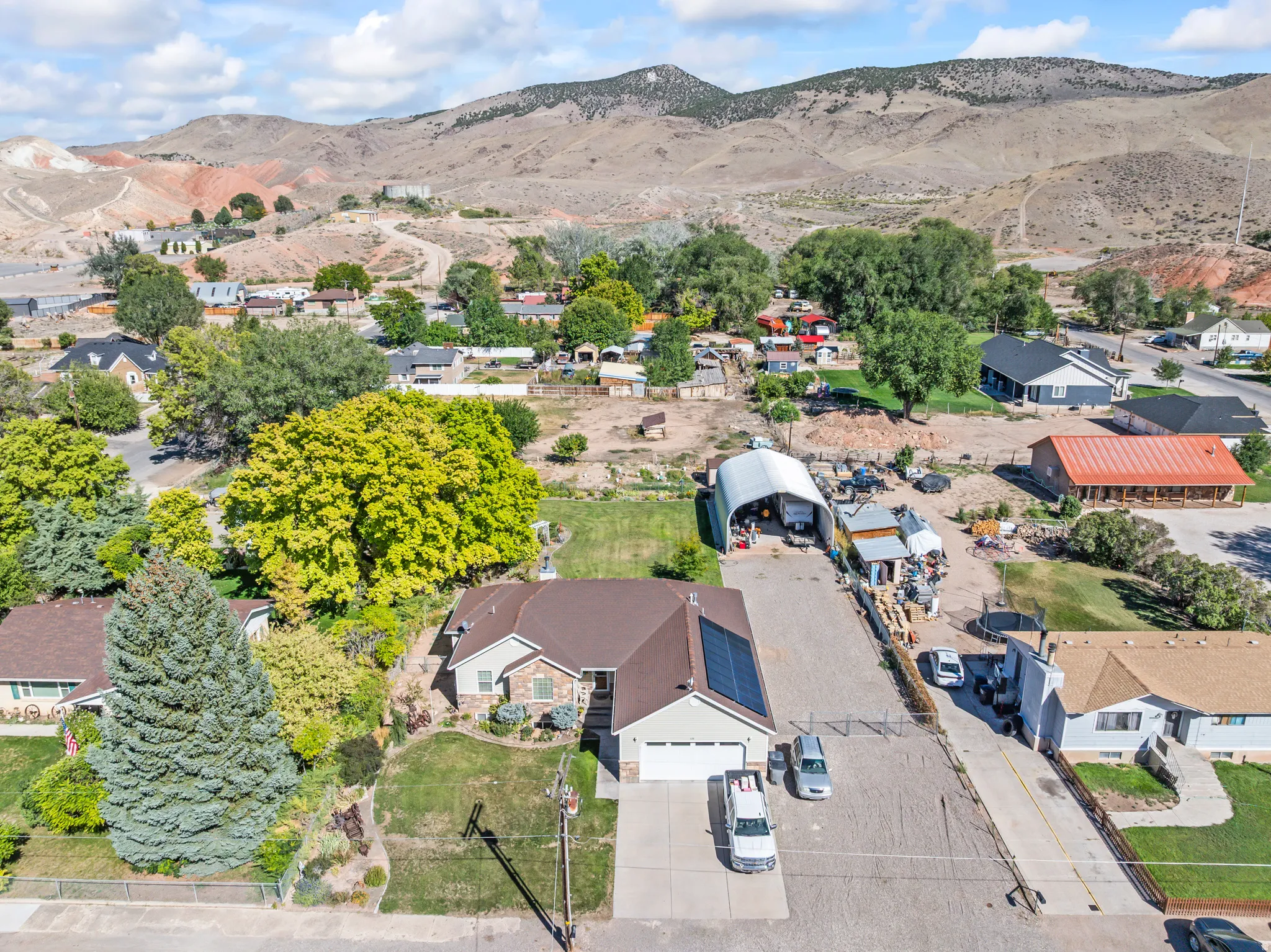Ranch-style residence featuring a two-car garage, solar panels, and a paved driveway