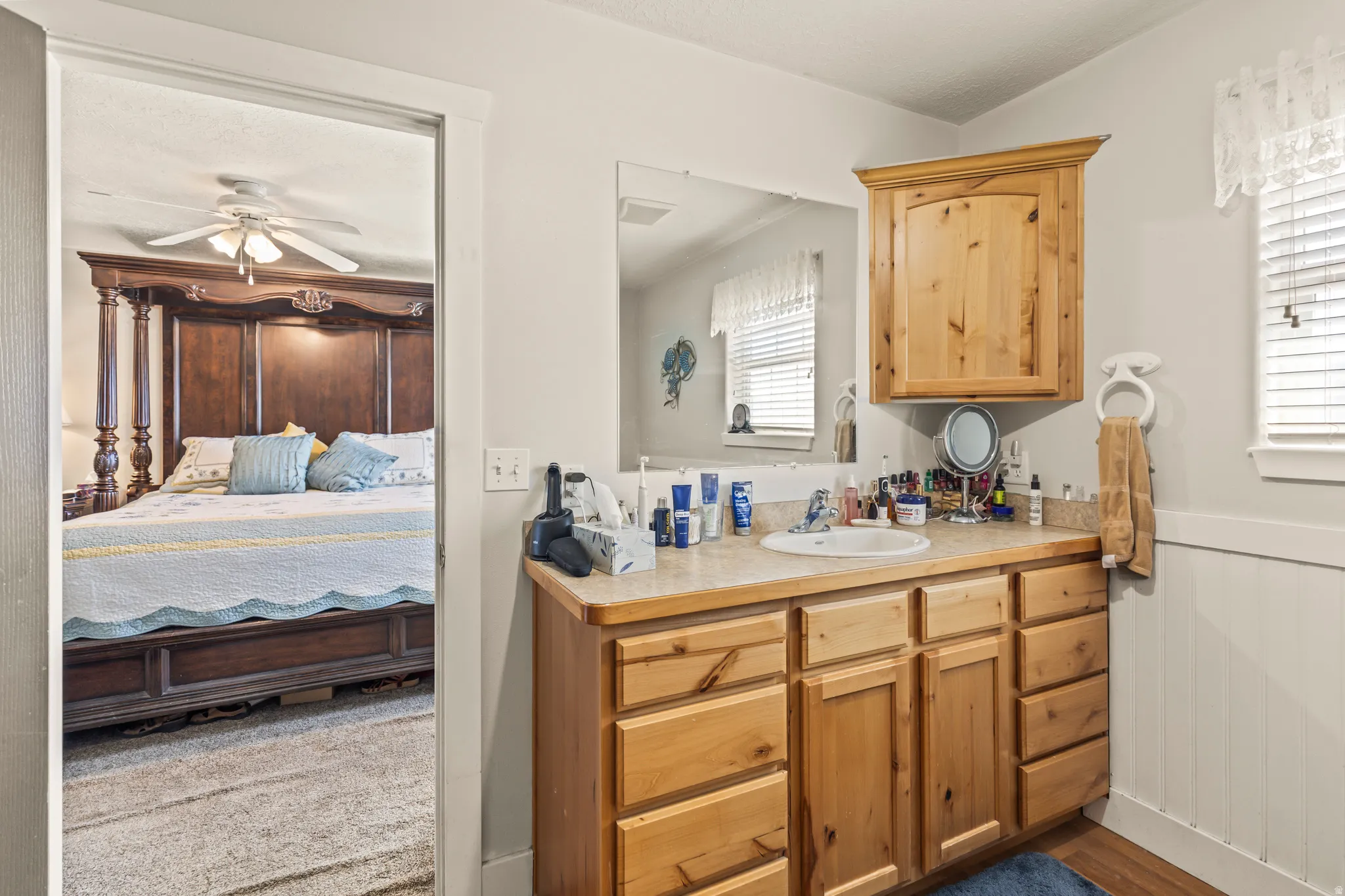 Vanity with wood-finish cabinetry, integrated sink, and laminate countertop