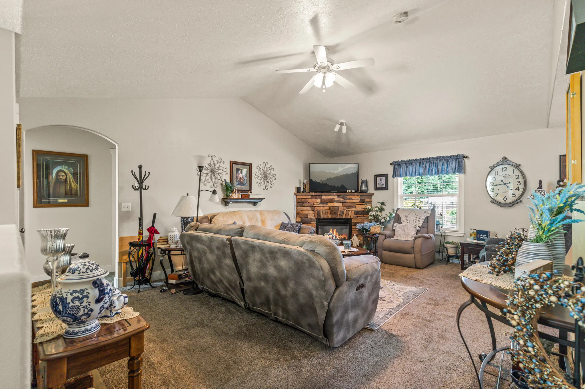 Vaulted ceilings complement the stone-faced fireplace with a wood mantel