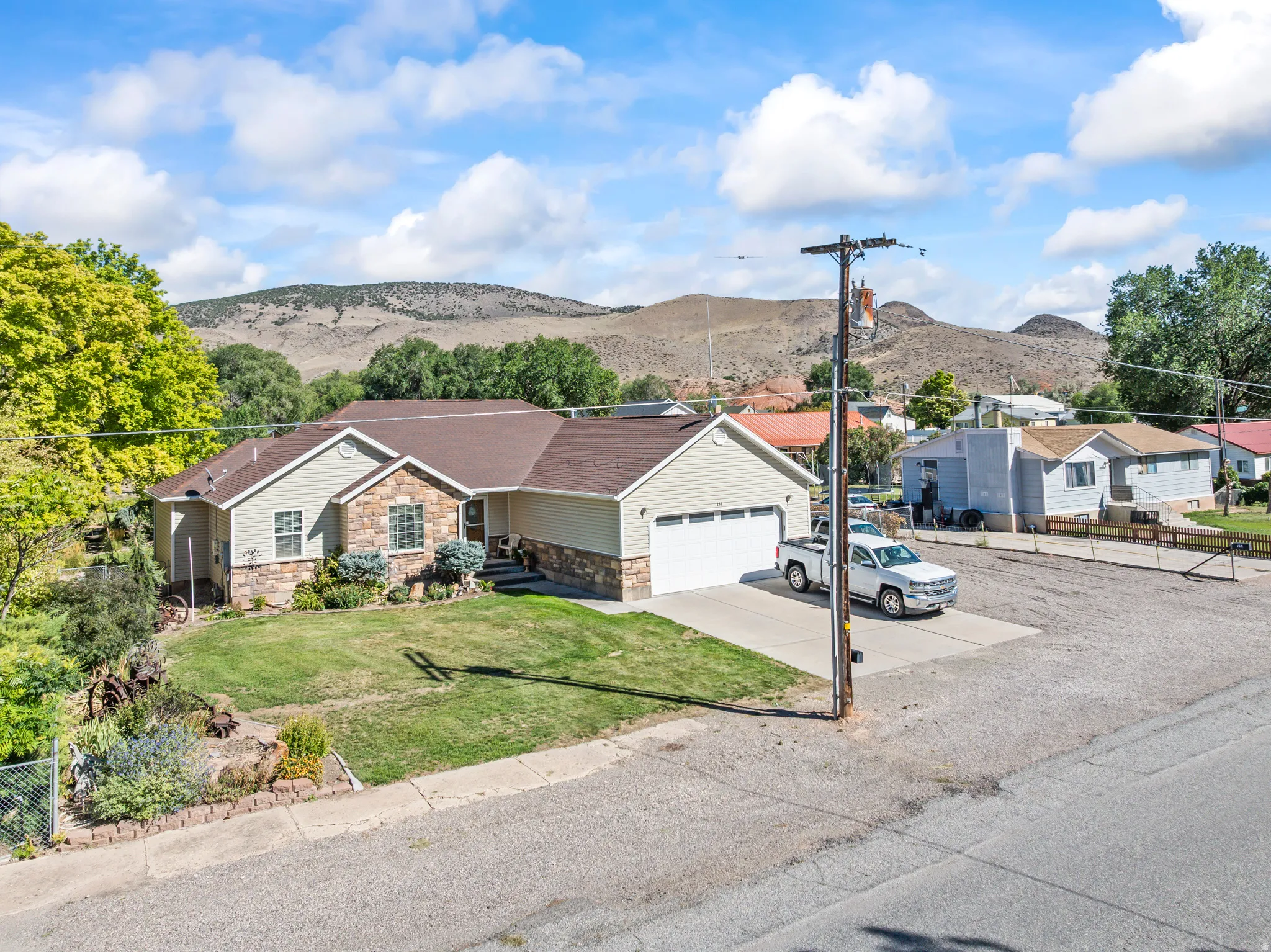 Ranch-style residence featuring a stone and siding exterior, an attached two-car garage, and a concrete driveway