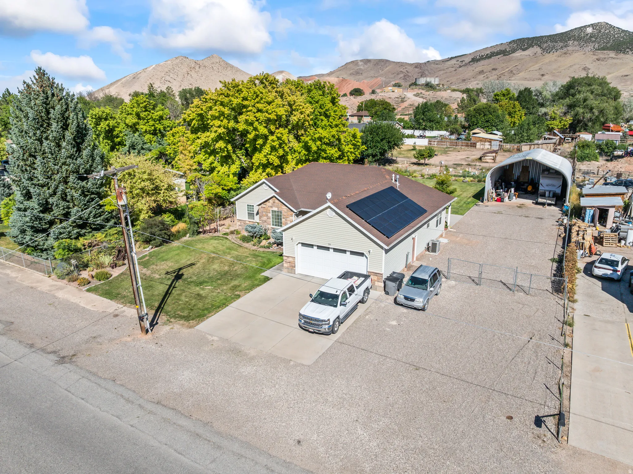 Single-story residence featuring a two-car garage, solar panels, and a stone facade accent