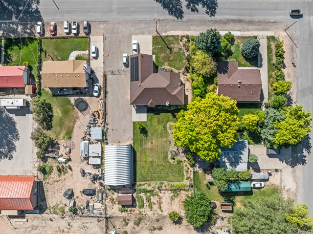 Expansive property with multiple buildings, mature trees, and paved parking areas