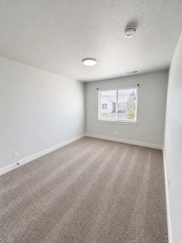 Carpeted flooring, white walls, window with blinds, and flush-mount ceiling light