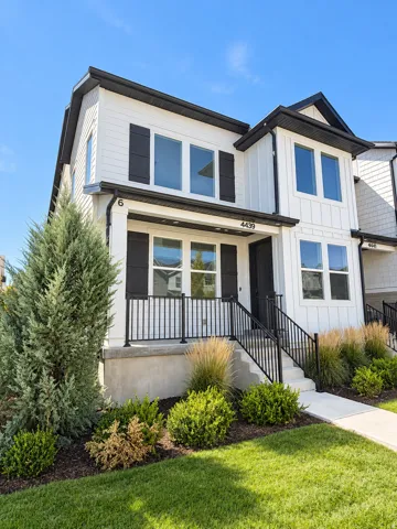 Two-story exterior with white siding, black window shutters, and a covered porch