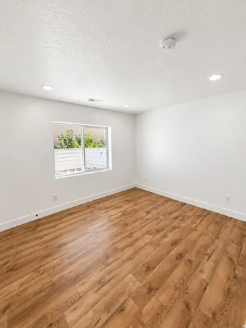 Recessed lighting, wood-finish flooring, and a large window