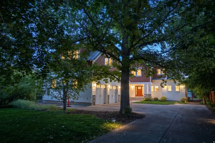 Craftsman-style exterior with white siding, red shake accents, and a metal roof