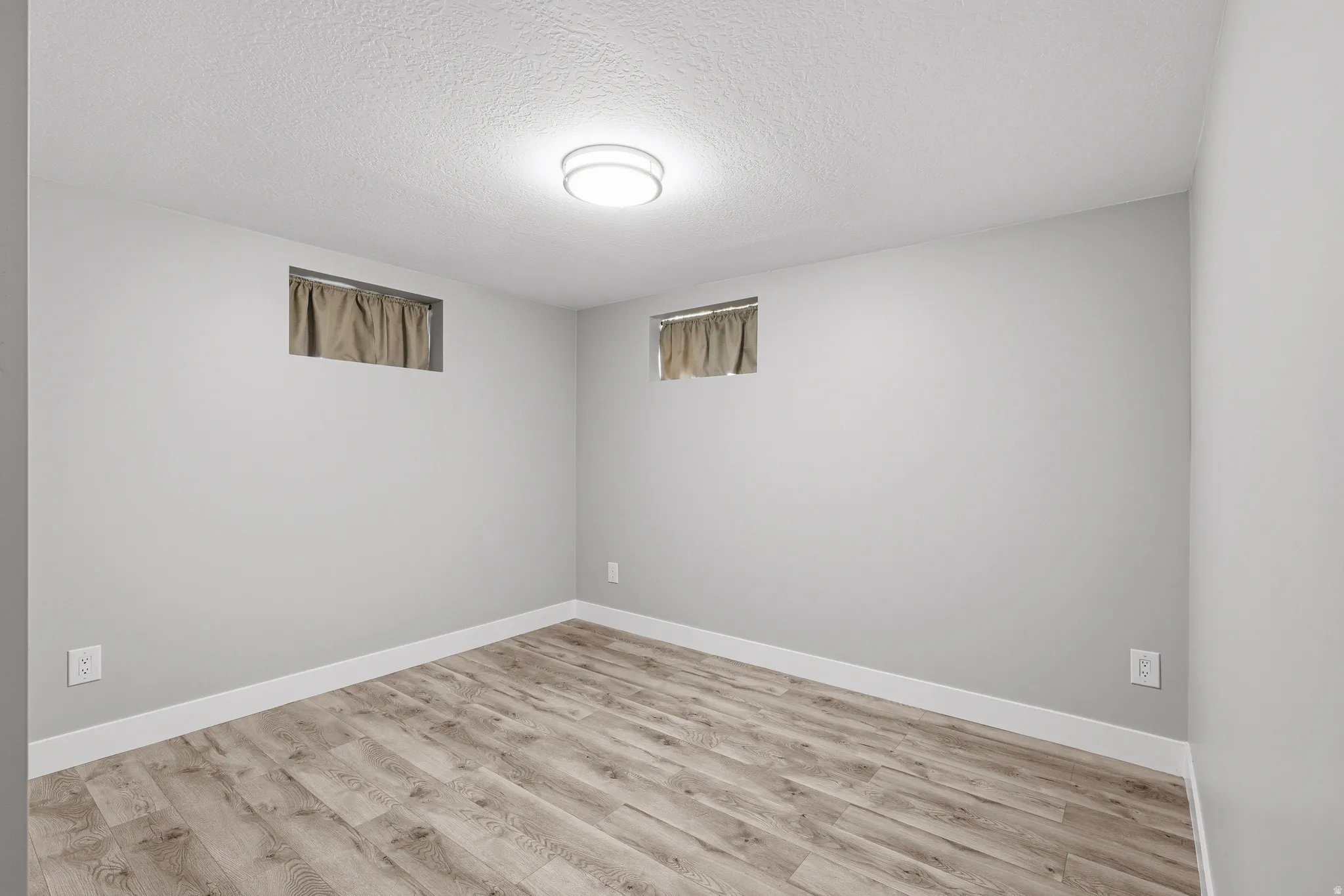 Lower level bedroom with laminate flooring and fresh neutral paint.