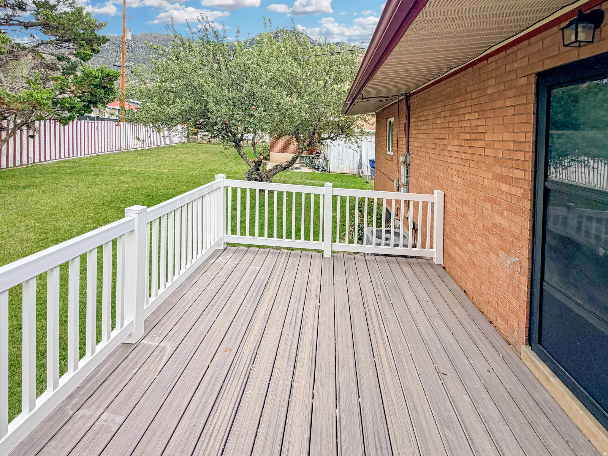 Brand new deck features vinyl railings and engineered wood surface