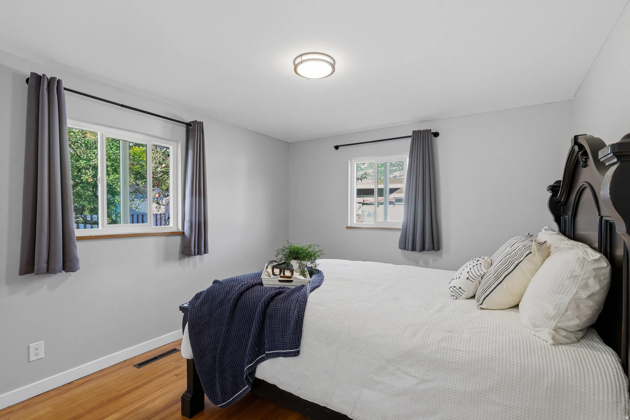 Main level bedroom with double updated windows, large closet, hardwood floors and fresh neutral paint.