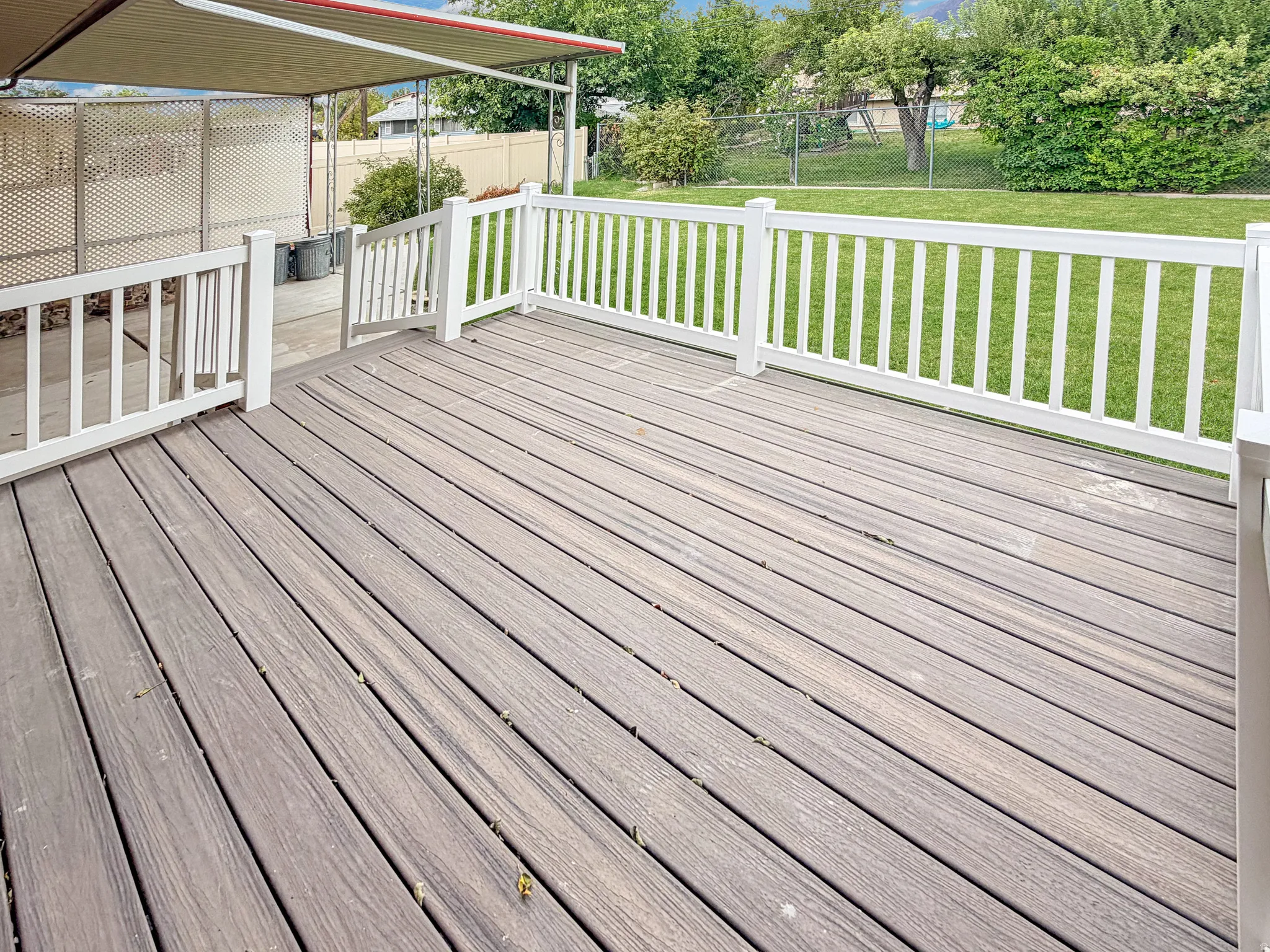 Brand new deck features vinyl railings and engineered wood surface