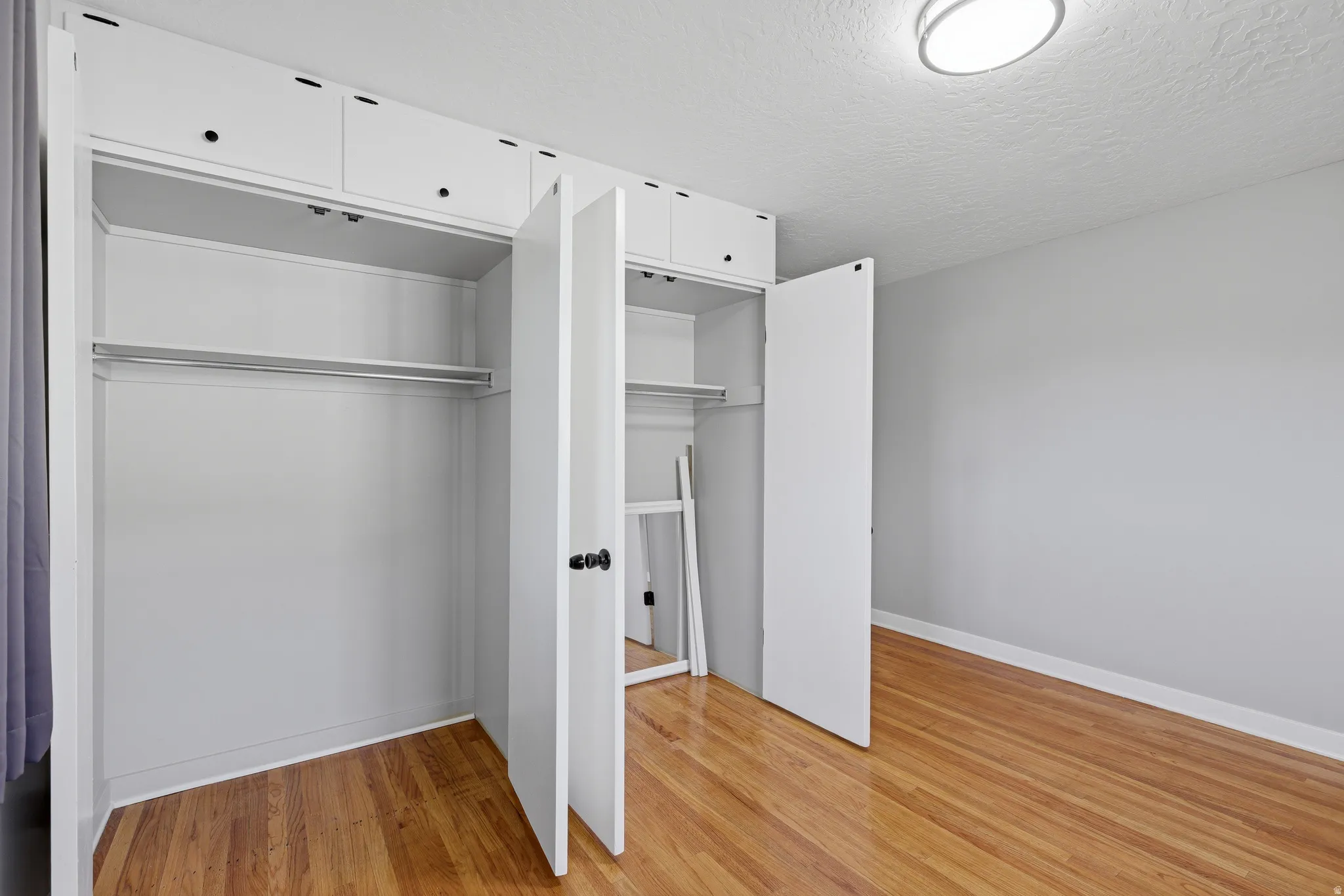 Main floor bedroom with double updated windows, hardwood flooring and fresh neutral paint