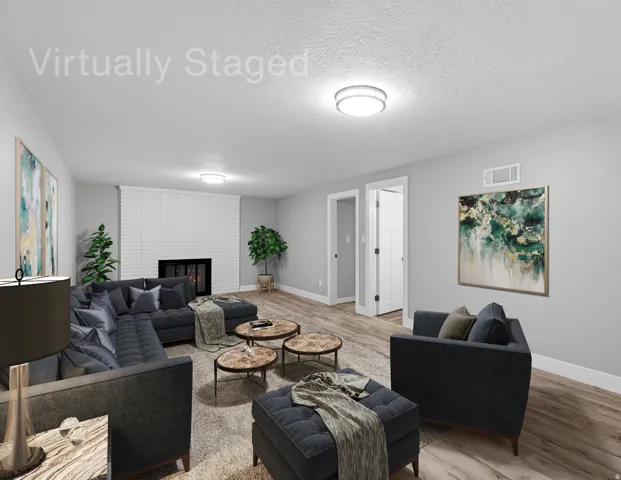 Lower level gathering space with fireplace, laminate flooring, fresh neutral paint and LED lighting.  Virtually staged