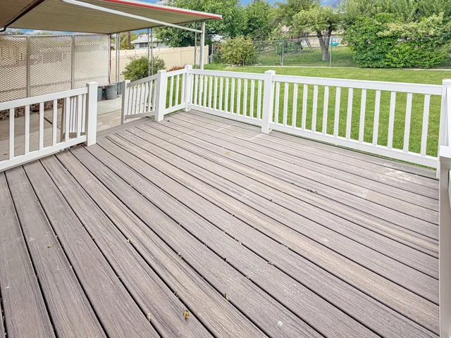 Brand new deck features vinyl railings and engineered wood surface
