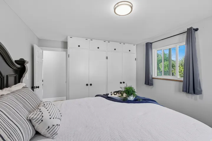 Main level bedroom with double updated windows, large closet, hardwood floors and fresh neutral paint.