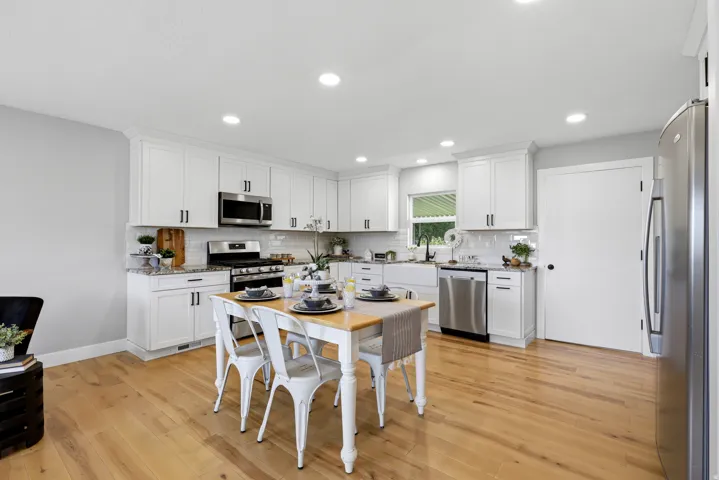 Farmhouse white kitchen with included refrigerator, hardwood floors and granite countertops